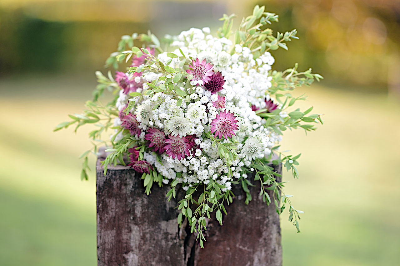 Vjenčani buket s bijelim i ljubičastim cvjetovima, bogat teksturama i suptilnim kontrastom boja.