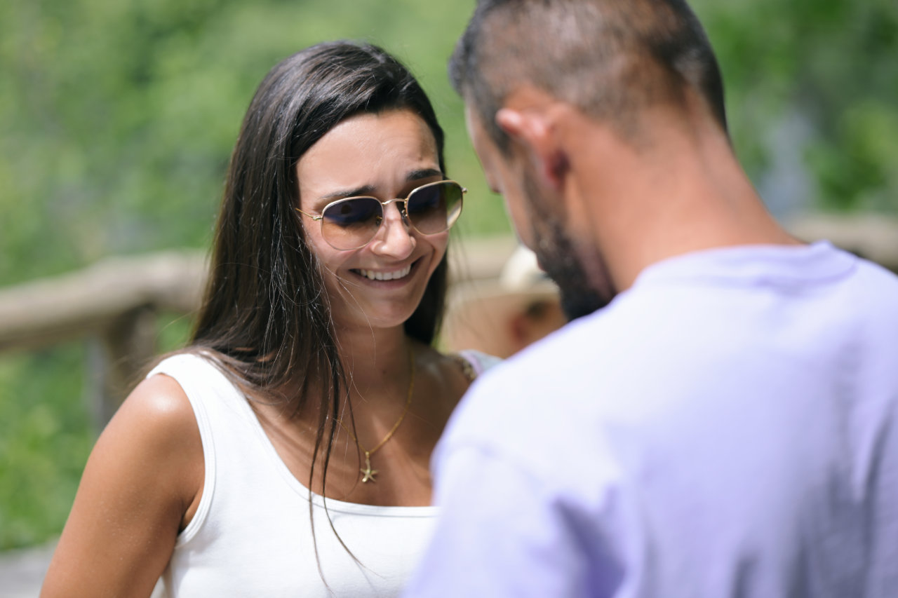 Emotivan trenutak prosidbe na Plitvičkim jezerima: krupni plan nasmijane djevojke s naočalama tijekom zaruka u prirodi.