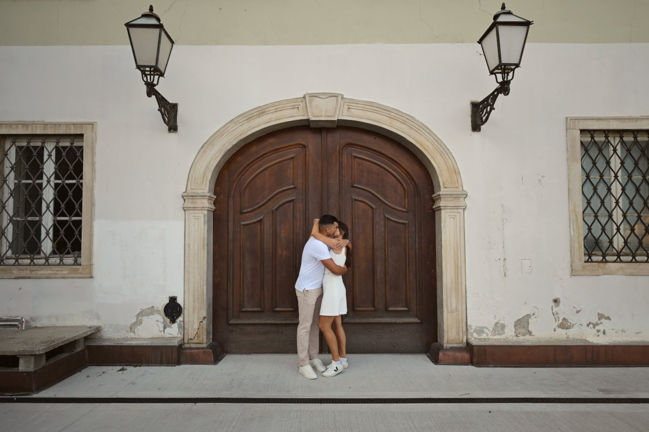 Par se ljubi ispred povijesnih vrata u Zagrebu, profesionalno fotografiranje zaruka na Gornjem gradu.
