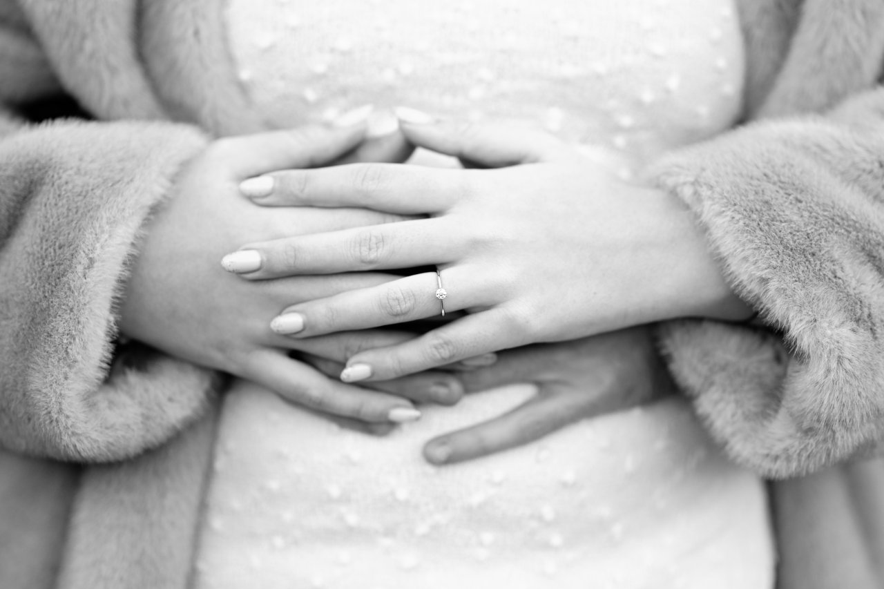 Crnobijela fotografija isprepletenih ruku Brune Bogojevića i njegove zaručnice s fokusom na zaručnički prsten.