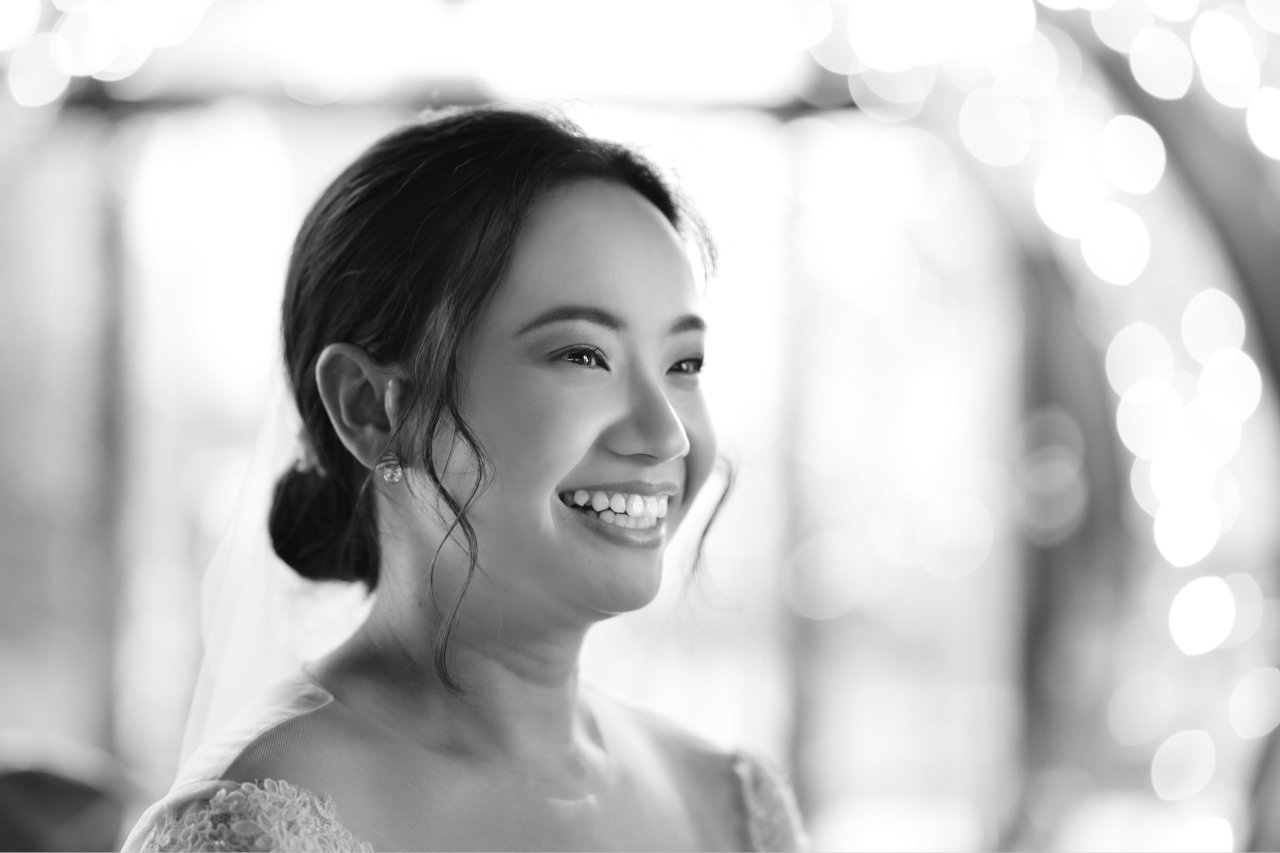 Crnobijeli portret mladenke ispred brojnih sitnih lampica koje stvaraju upečatljiv bokeh.