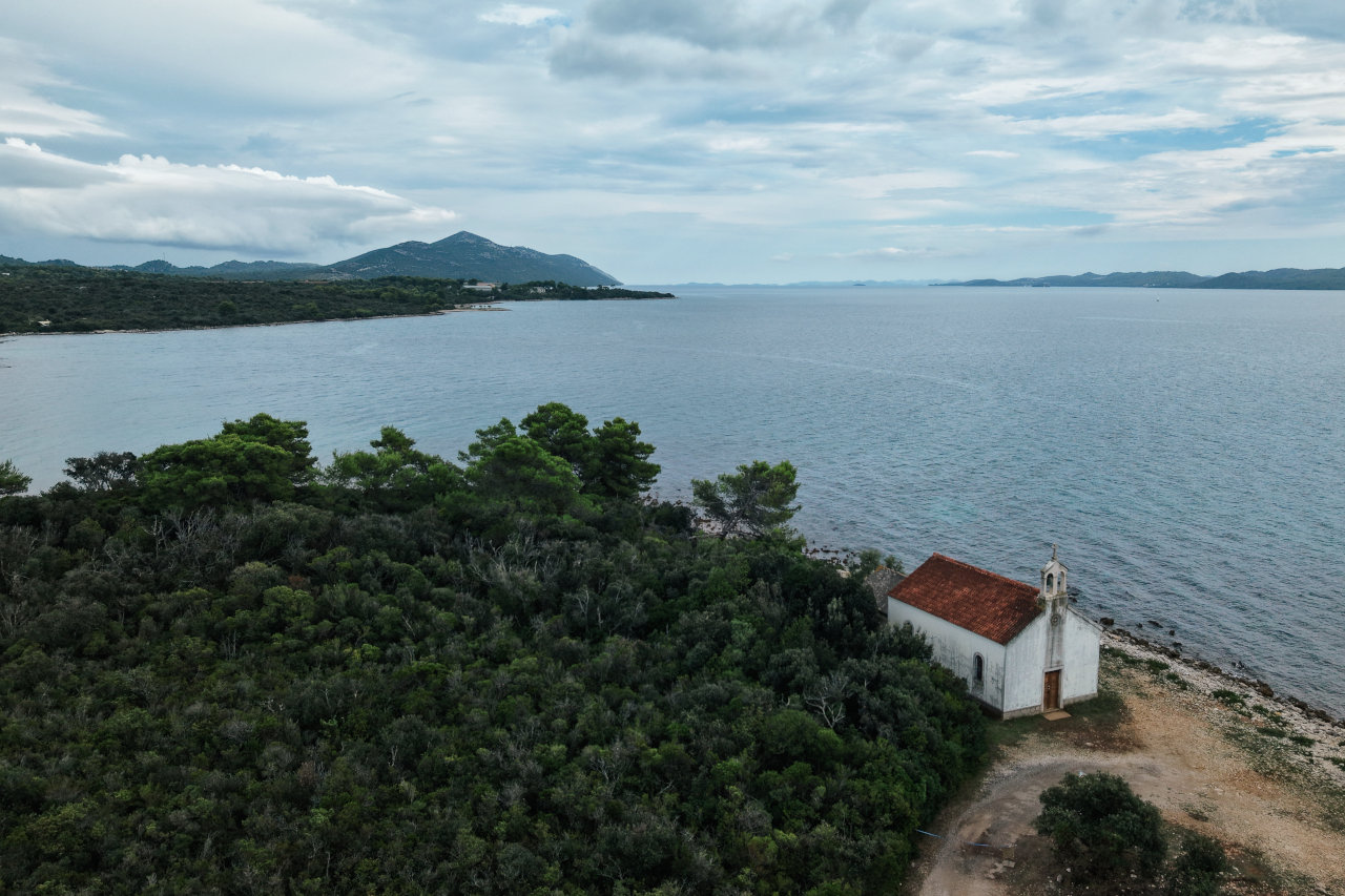 Pogled iz zraka na crkvu sv. Kuzme i Damjana uz obalu mora na otoku Ugljanu.