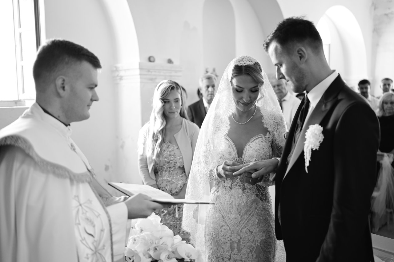 Crnobijela fotografija razmjene prstenja i crkvenog obreda vjenčanja u crkvi sv. Kuzme i Damjana.