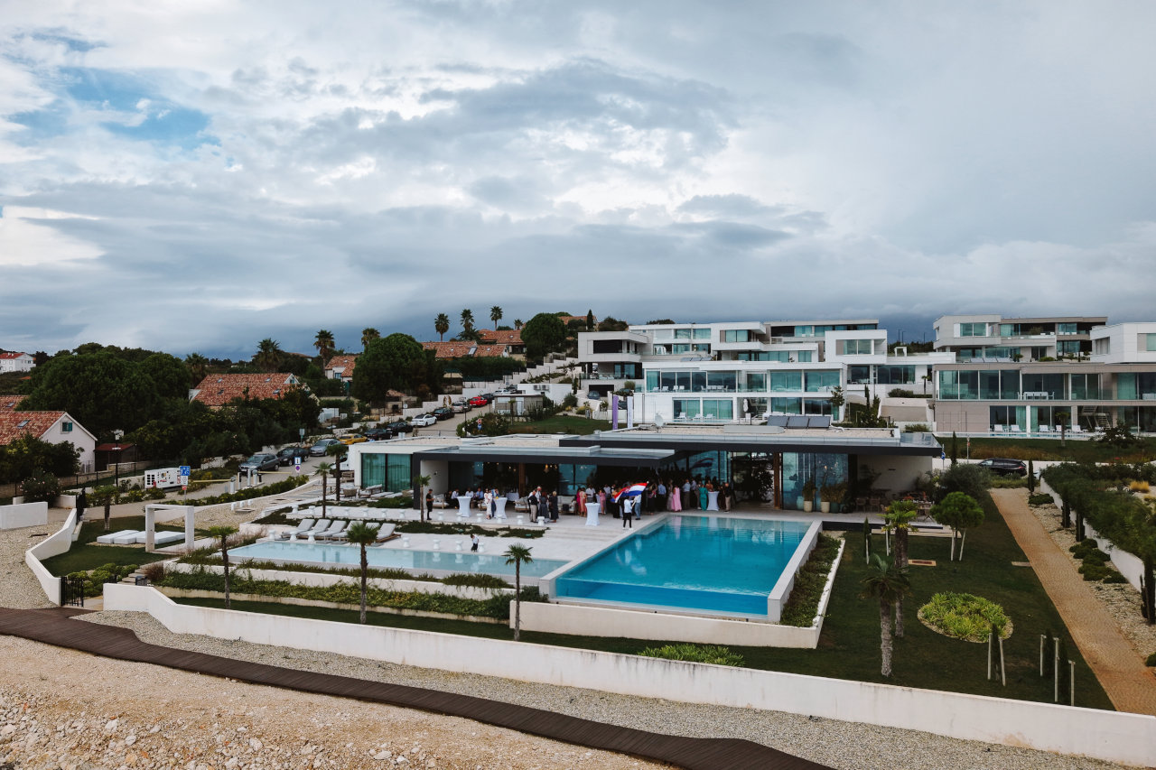 Panoramski pogled na luksuzni Lioqa Resort s bazenom i uzvanicima na vjenčanju na otoku Ugljanu.